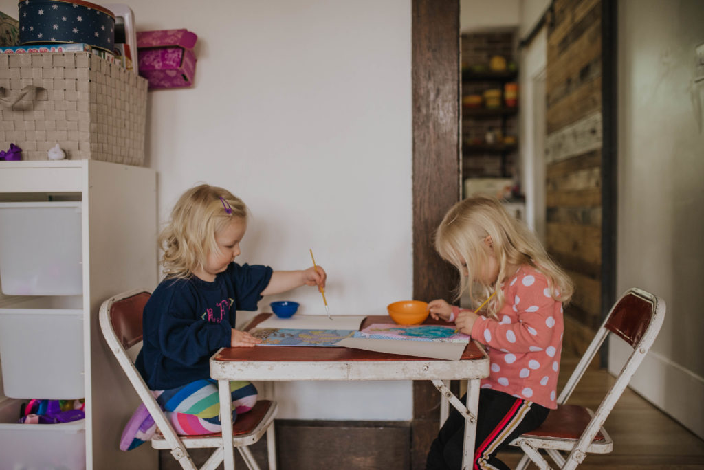 two toddlers painting at a table