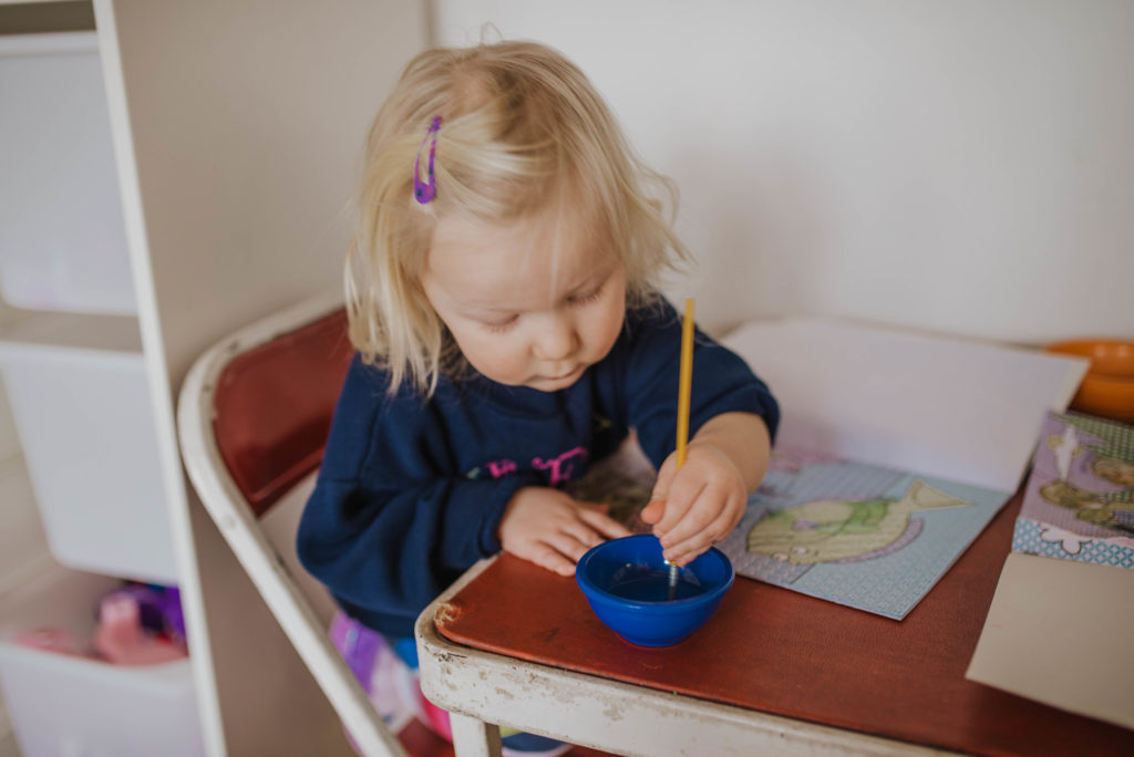girl toddler painting at a table